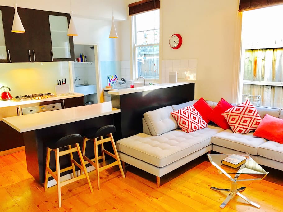 Bright and cheerful open-plan living with a super comfy couch and handy breakfast bar.