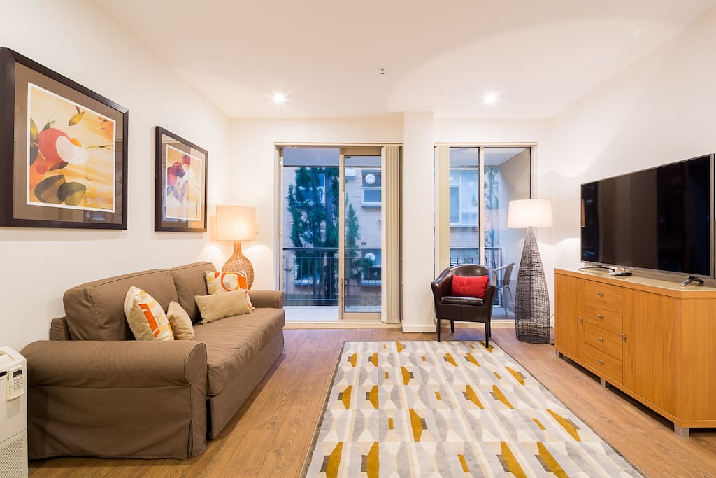 Comfortable living room with a double size sofa bed and 58" UHD Smart TV in this 1-bedroom StayCentral St Kilda Serviced Apartment