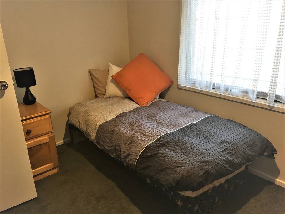 Comfy bed with bedside table and lamp. Under bed storage.
