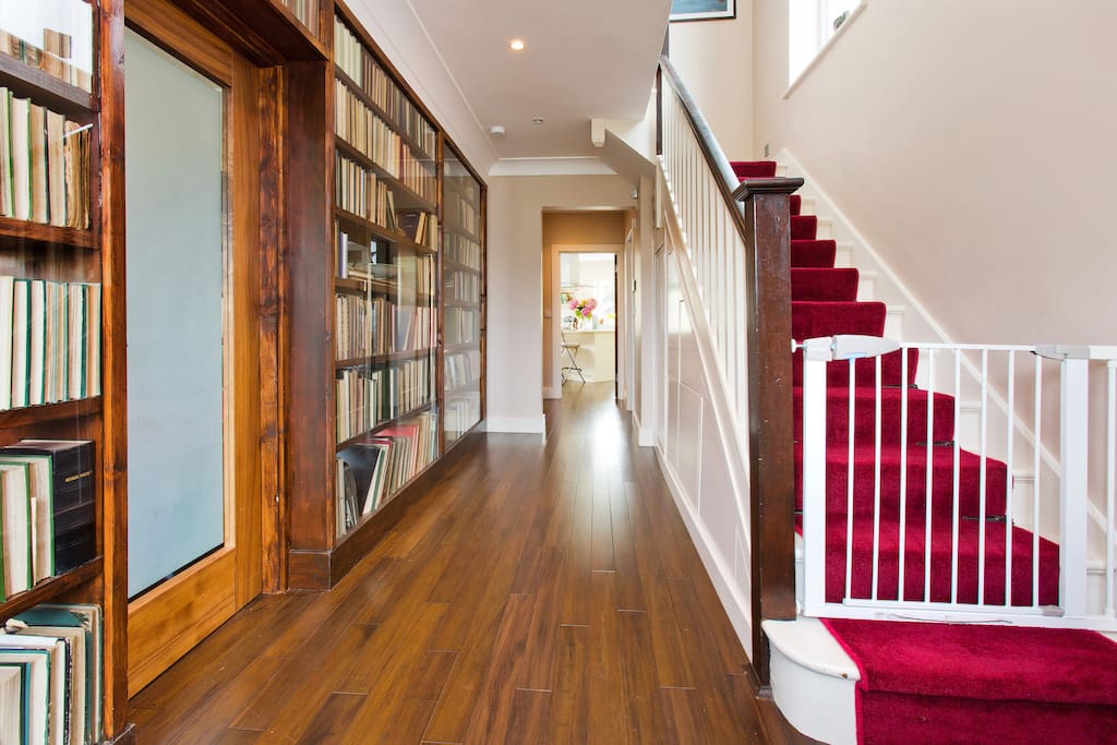 The entrance hall with wall of books leading into the library.