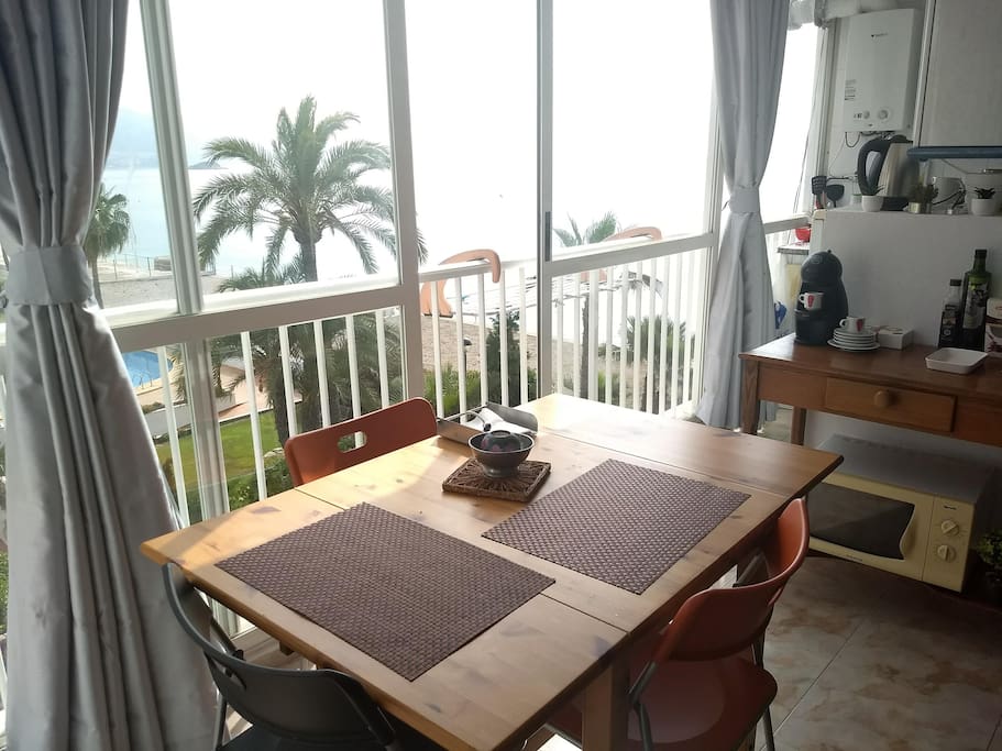 Four-person dinning table overlooking the five-meter wide wall-to-wall window overlooking the sea view below.