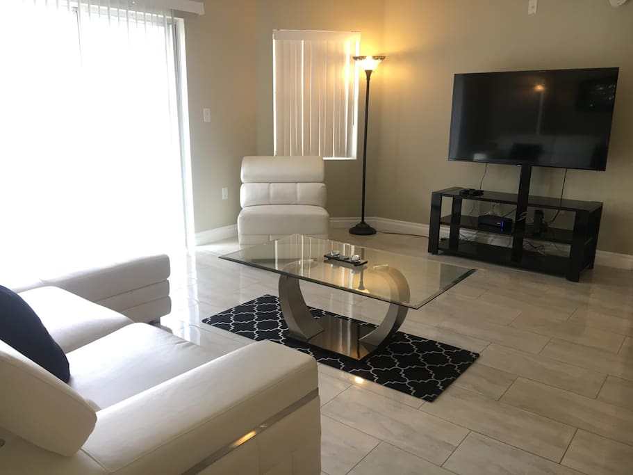 lovely white couches very comfortable and a glass living room table.