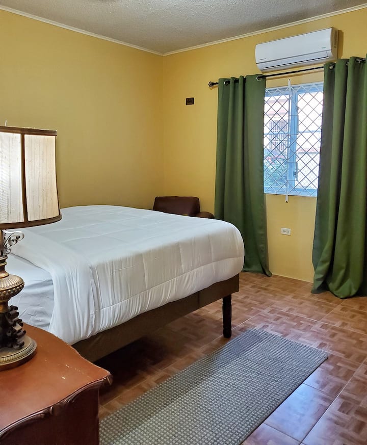 Primer dormitorio con una cama tamaño queen