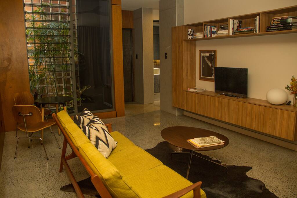 Living area with sofa and small dining suite. Plenty of books and magazines to browse through.