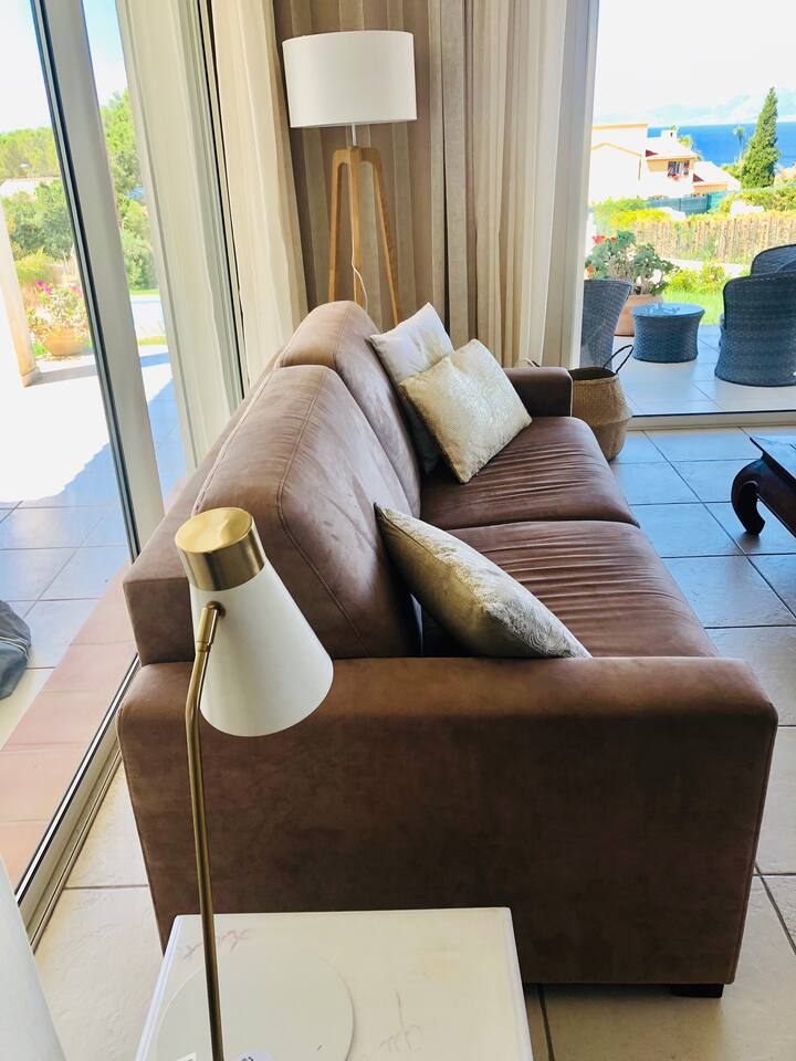 Salónik s televízorom s veľkou obrazovkou a výhľadom na more 