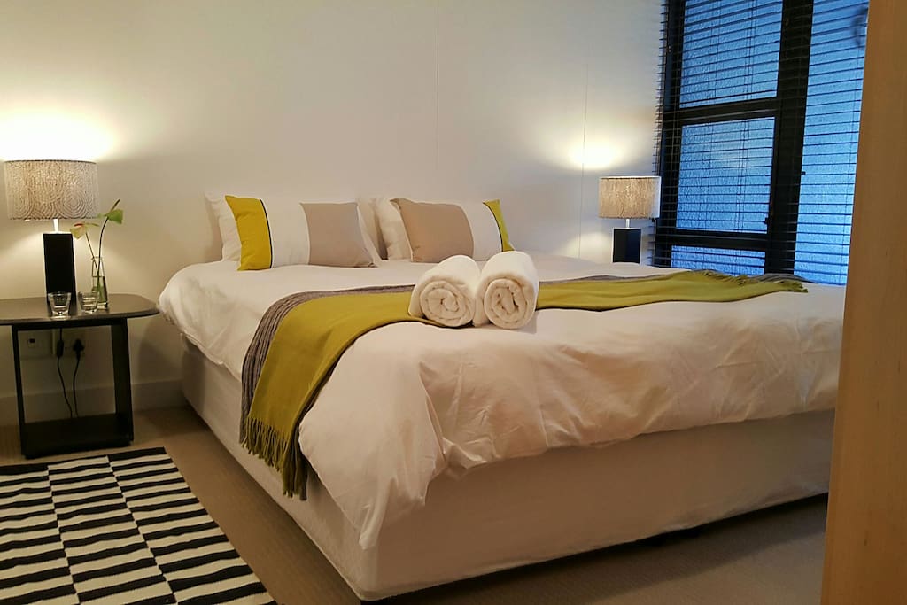 Bedroom with king extra length bed, leads onto open balcony. Ensuite bathroom.