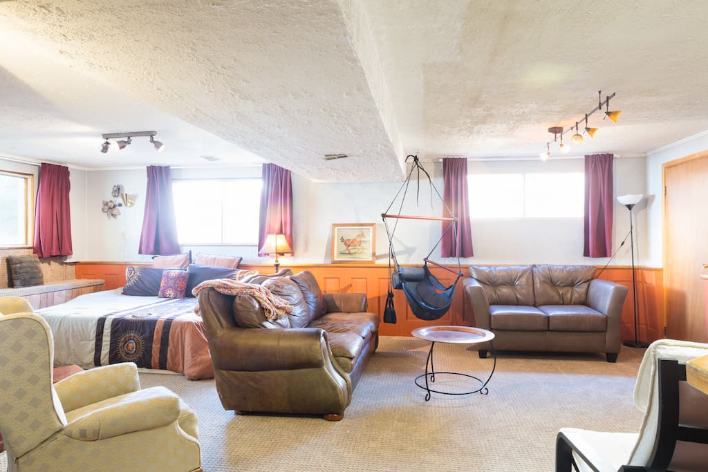 A nice comfy leather couch, a fun swing chair and that door is a huge cedar closet just for you, complete with fluffy bathrobes!