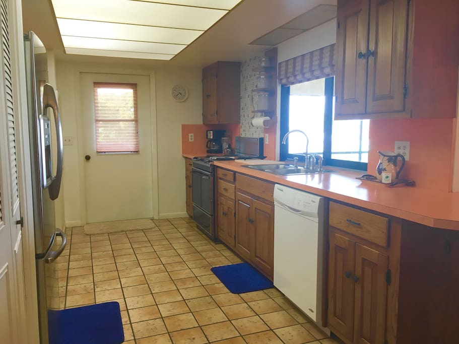 Kitchen has stainless steel fridge with ice maker , dishwasher , stove , oven pots pans dishes blender coffee maker . Home away from home