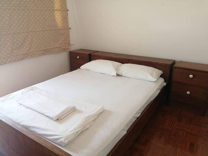 Second bedroom with queen bed, mosquito net over bed and AC Unit. 