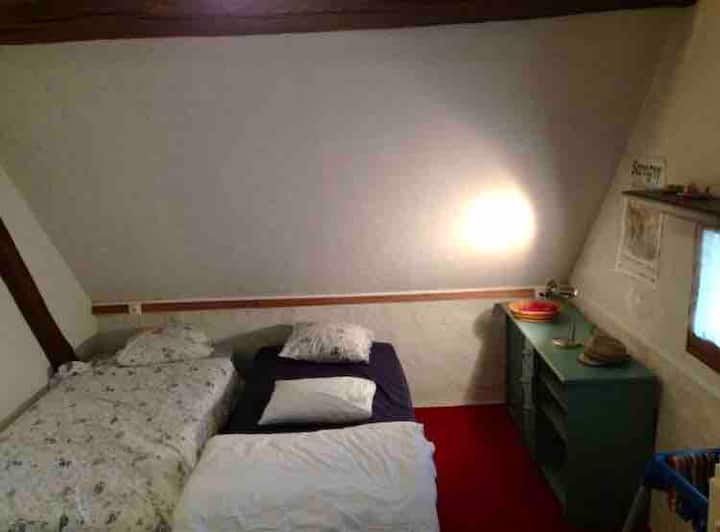 Chumba cha kulala cha kwanza ghorofani na vitanda 3 vya mtu mmoja,  na dari ya juu sana. Kuna kiyoyozi katika chumba hiki cha kulala