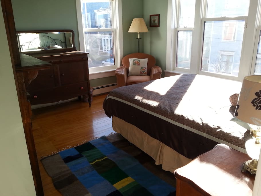 Queen sized bed, dresser, large windows view of the water.