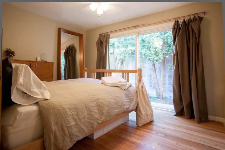 外のデッキへのドアのあるマスターベッドルーム、クイーンサイズベッド。