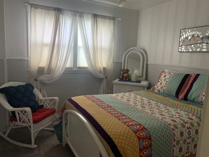 Kjo dhomë gjumi ftuese ka një krevat dopio, një karrige të rehatshme lëkundëse dhe një komodinë të vogël me pasqyrë.  Dritaret duken në oborrin anësor me bar dhe shkurre.