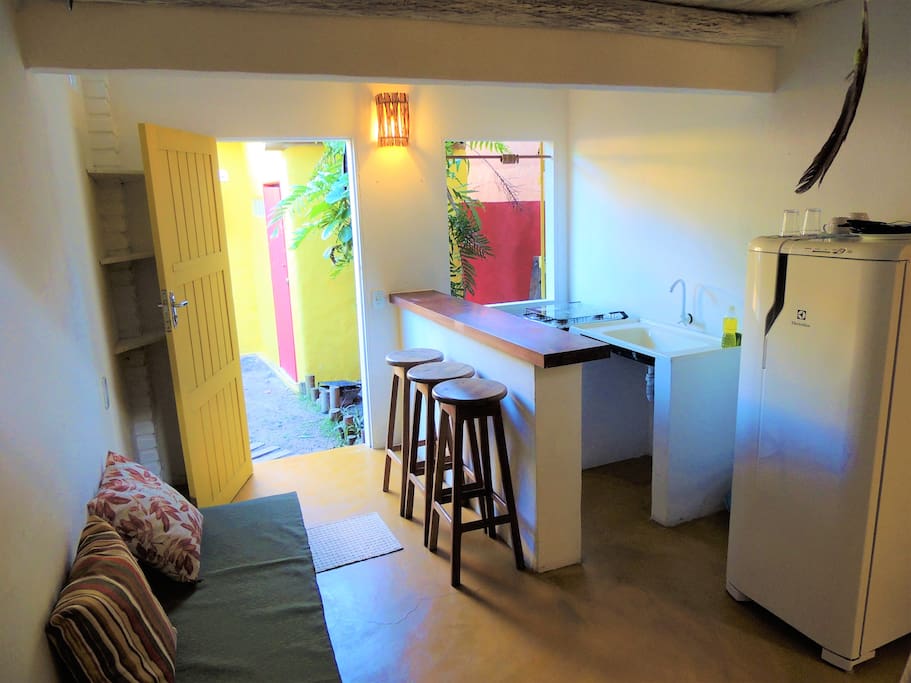 Cozinha compacta com fogão, geladeira, pia, balcão e utensílios