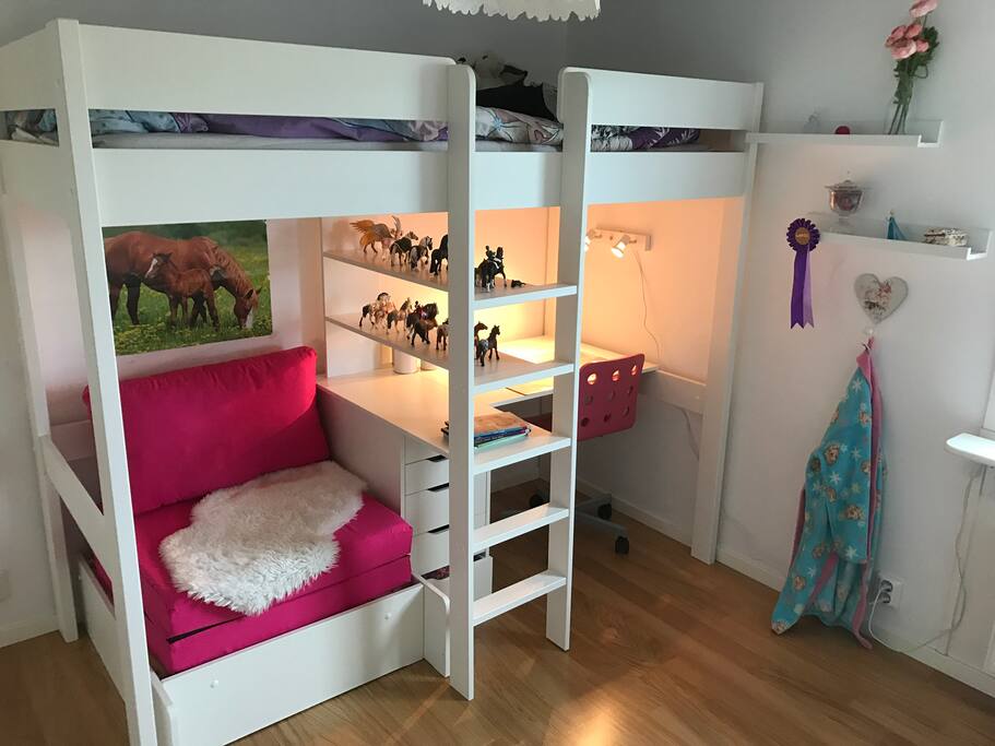 Sovrum med loftsäng och bäddfåtölj