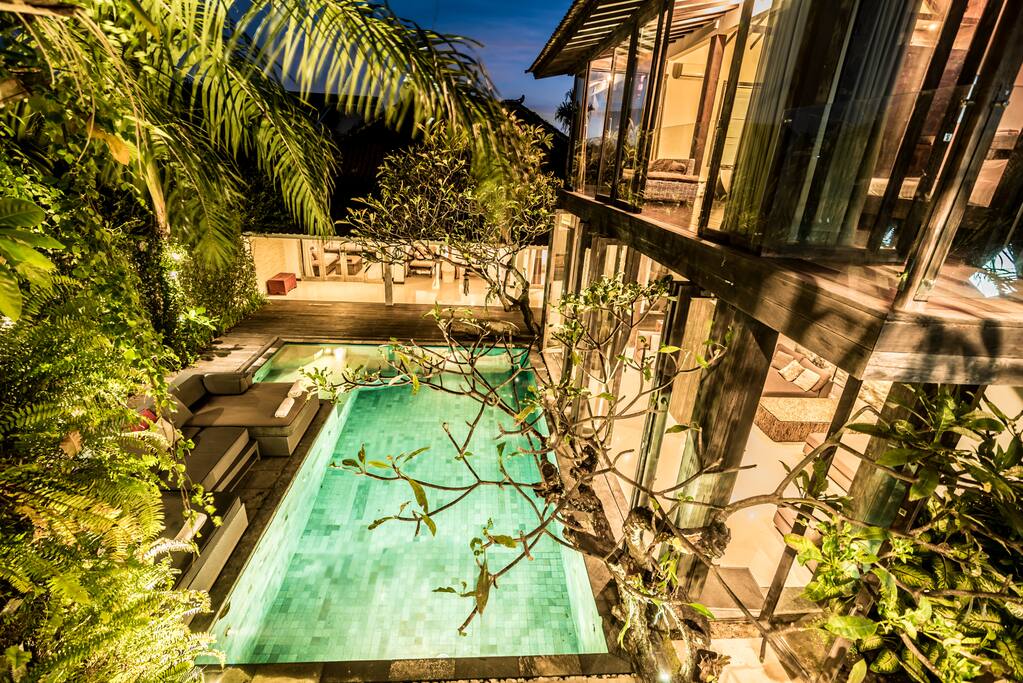 The luxurious pool area is beautifully lit in the evenings