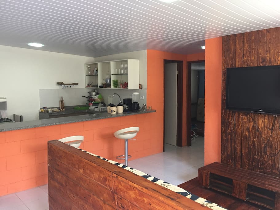 Casa principal com sala, cozinha americana, 2 quartos (1 suíte) e banheiro social.