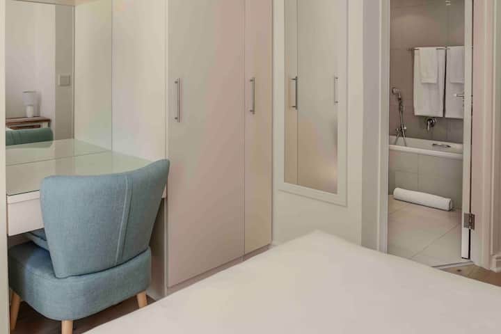 تحتوي غرفة النوم الرئيسية على مكتب مدمج في فانيتي مع مرآة.