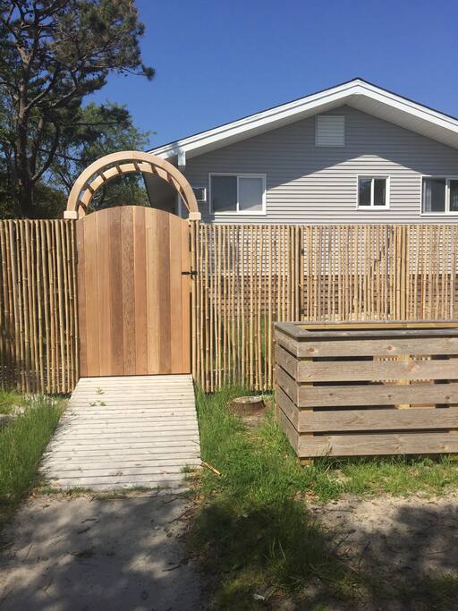 Brand new totally enclosed bamboo and deer fence with arbor and lattice decking and a new door for privacy.