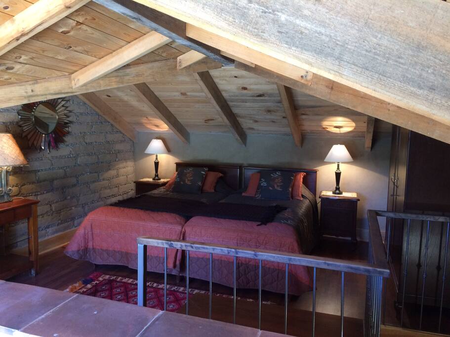 Loft acogedor diseñado en Adobe y madera, con dos camas individuales.