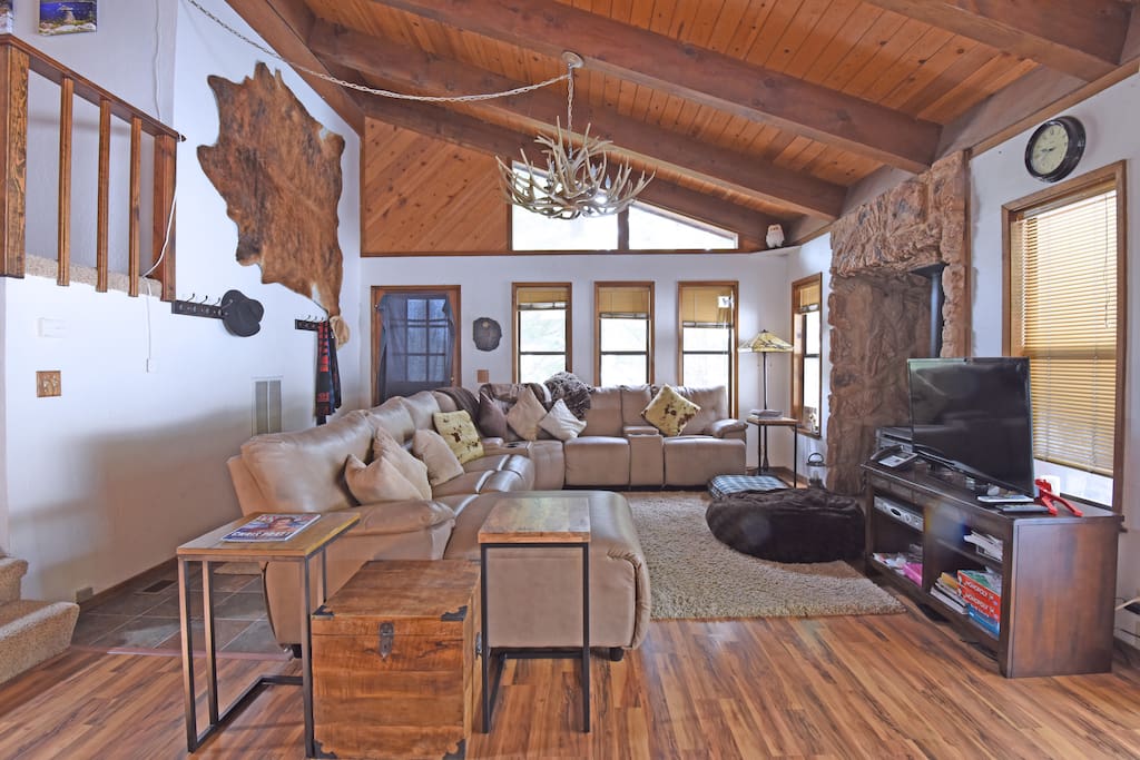 Living room with spacious couch, flat screen TV, and gas fireplace