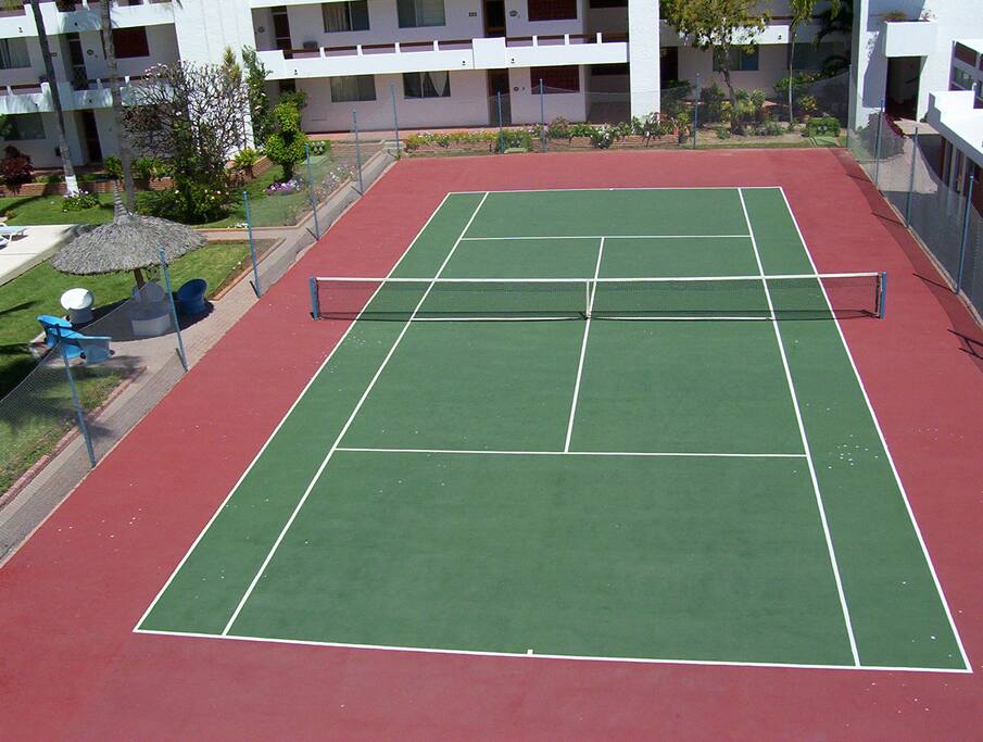 The tennis court next to the pool.