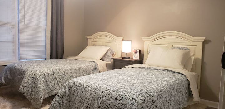 Comodi letti singoli con finestra di grandi dimensioni, poltrona reclinabile e smart tv.