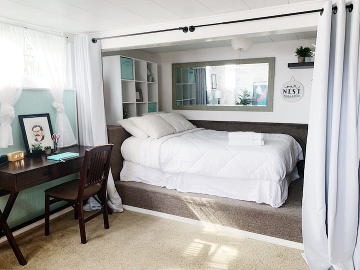 The comfortable queen bed is nested in a bed nook with black-out curtains for privacy and shade.