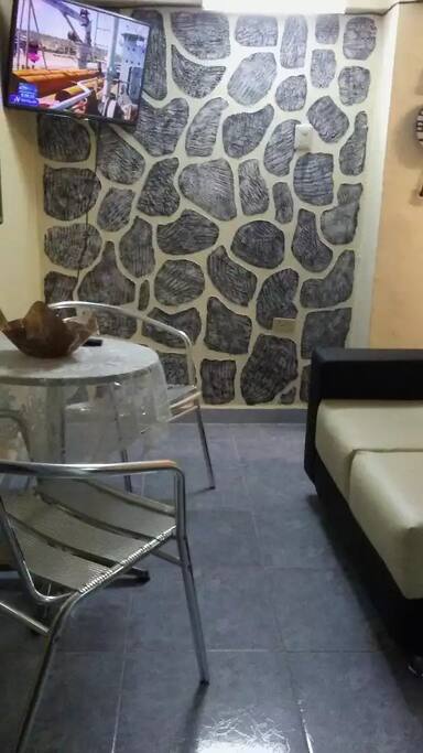 Comfortable living area with sofa, tv, table and chairs. Ice cold AC.