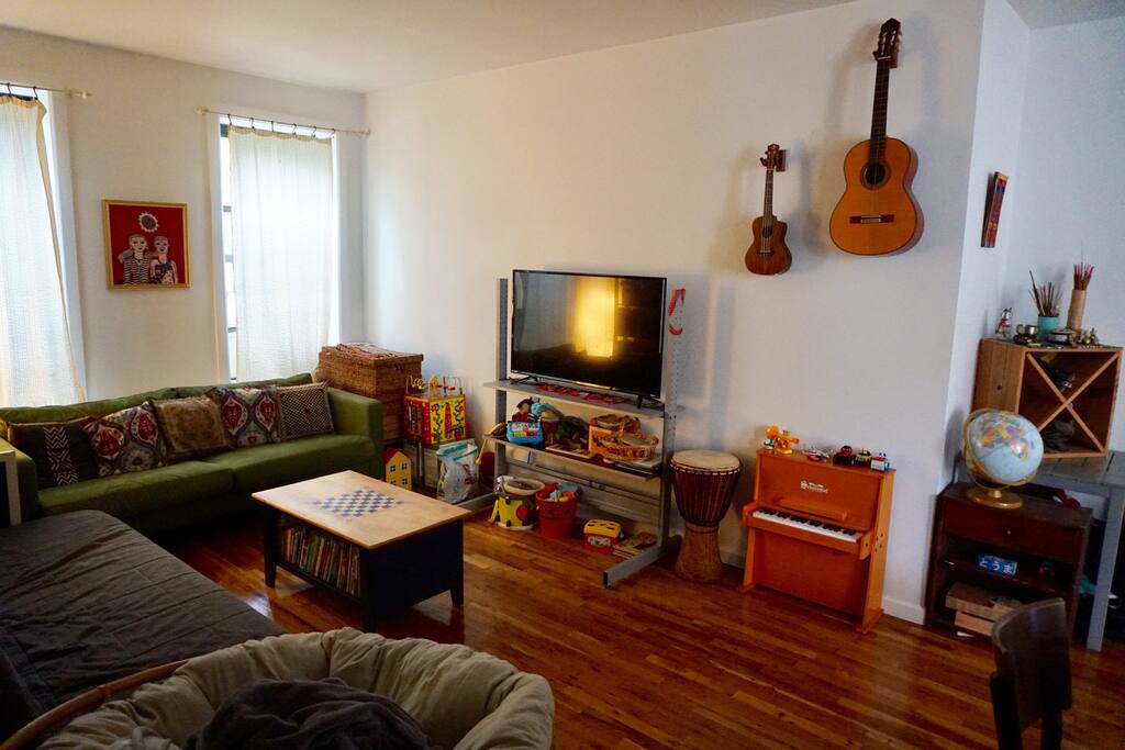 View of the living room from the hallway. You're welcome to play the musical instruments as well as watch Netflix, Spotify or YouTube on the TV.