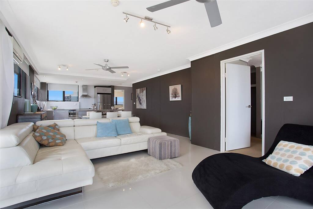 Spacious living room with ocean, river and mountain views.
