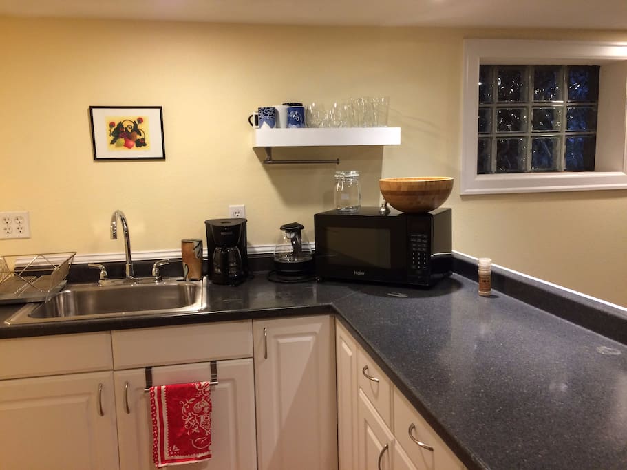 Kitchenette with a fridge, microwave, coffee pot and electric kettle. It is well equip for breakfast, snacking and more.