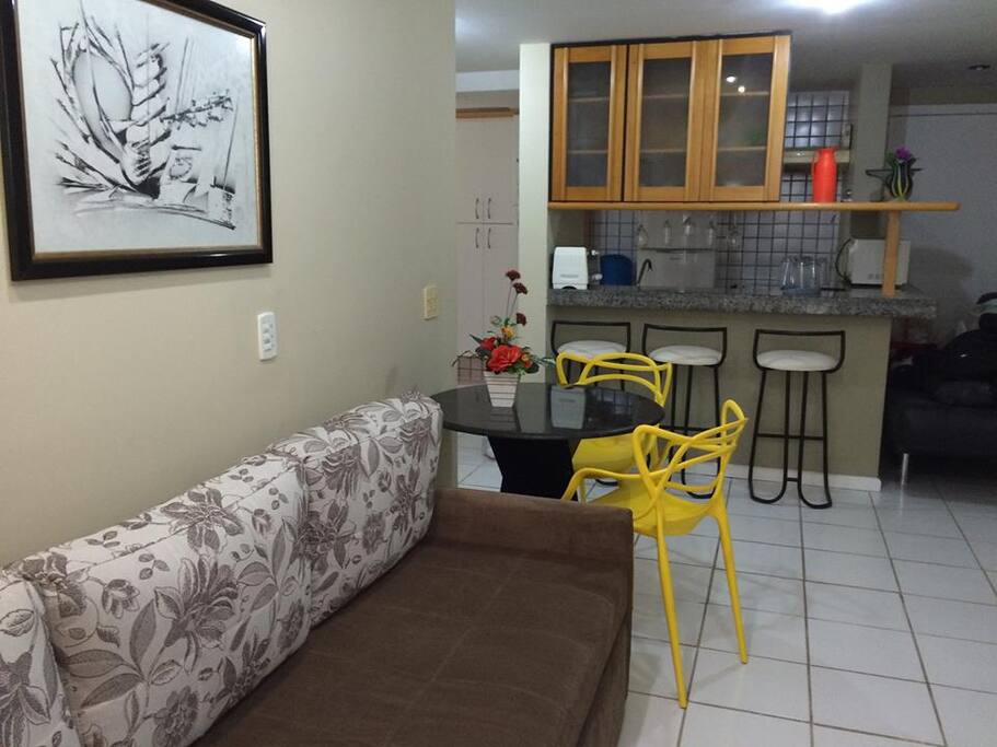 Apartamento com cozinha do tipo americana toda equipada com geladeira, forno microondas, forno elétrico, fogão, vasilhas, talheres, pratos... cozinha completa
