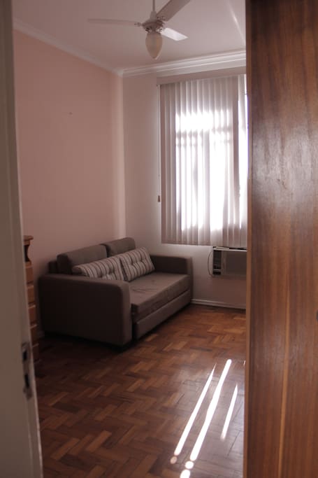 O quarto fica bem espaçoso com o sofá fechado