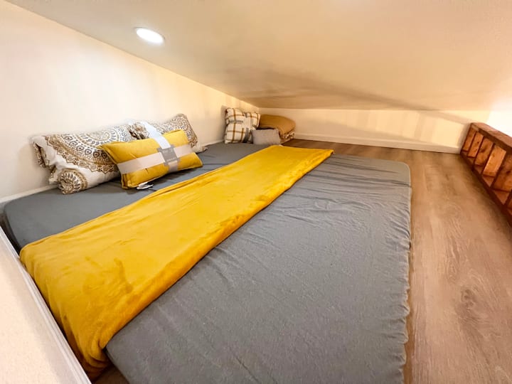 The sleeping area on the loft, furnished with a large and comfortable king size mattress, along with extra bedding.