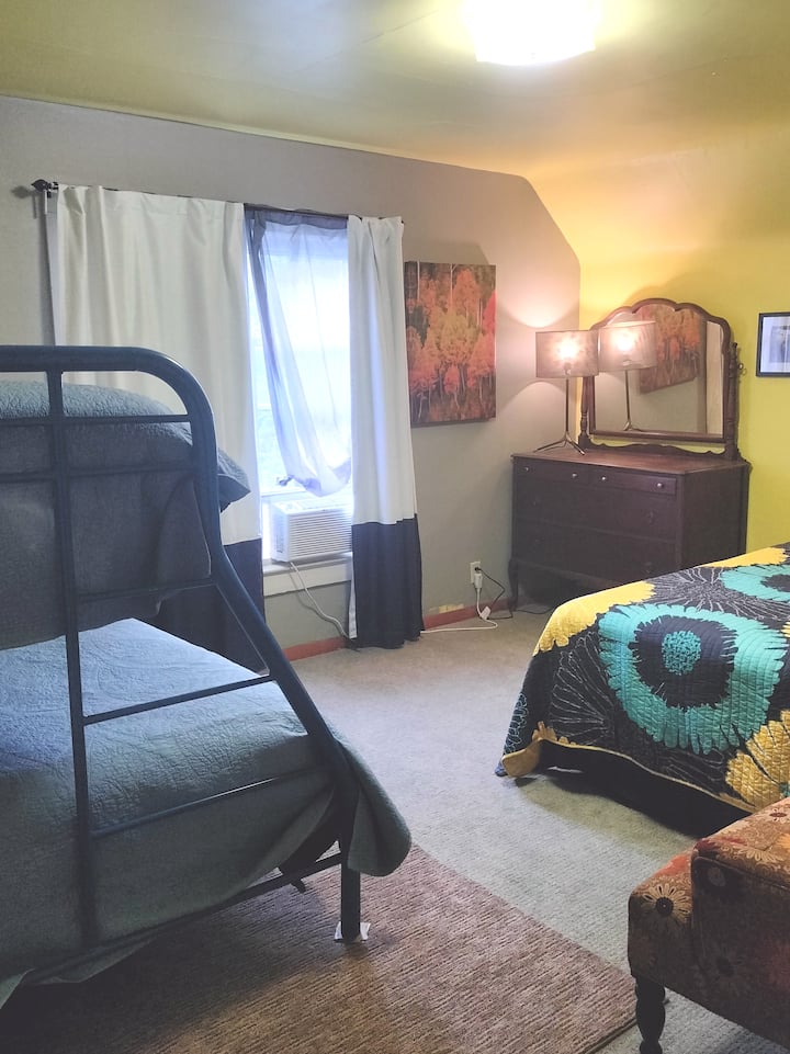 3rd Bedroom Upstairs: 1 Queen, 1 Full and 1 Twin. Closet, dresser and arm chair.  Window AC and Radiator Space Heater. One outlet.