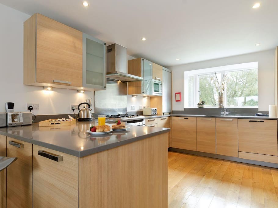 Fully equipped kitchen with double oven and bar stools for additional seating.
