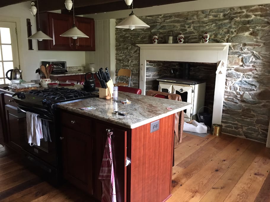 My newly renovated spacious kitchen with reclaimed red oak floors, hand built cherry wood cabinets, beautiful granite counter tops and featuring my new La Nordica wood cookstove (think Rayburn or Aga) in the fireplace to supplement my gas range. The kitchen sink and fridge freezer are behind the island.