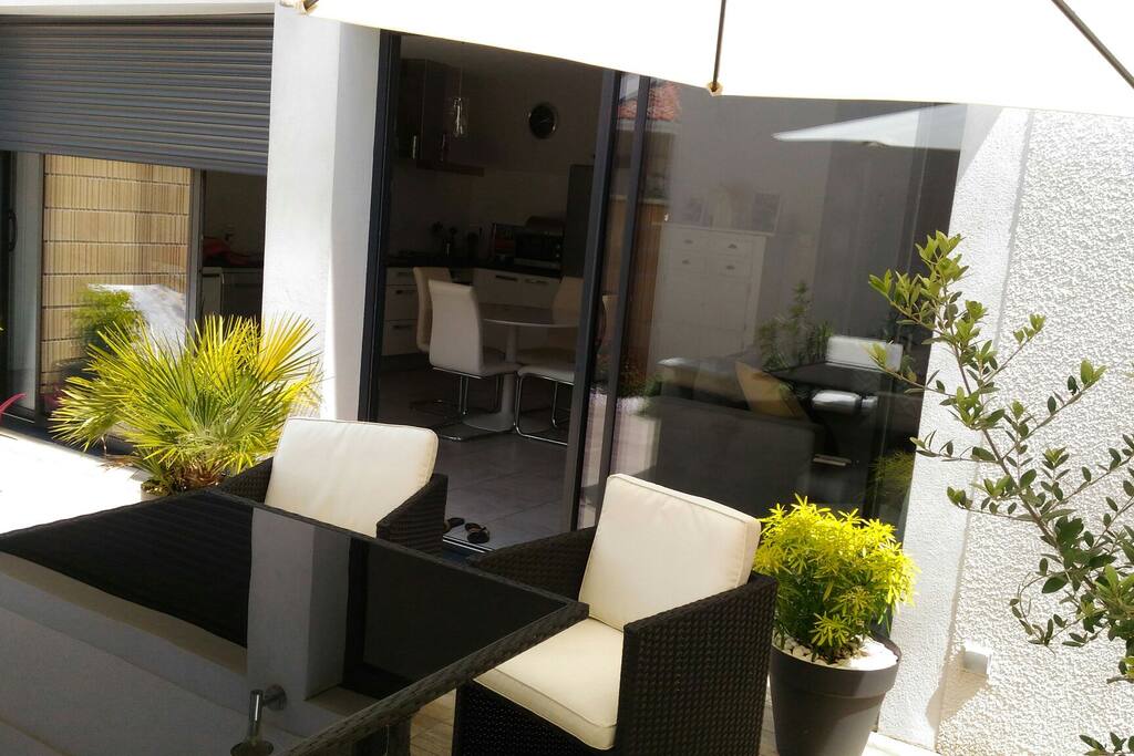 Terrasse spacieuse et végétalisée, prévue pour des repas en extérieur