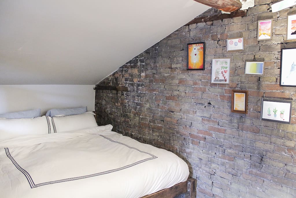 Cozy sleeping nook that features a king size bed, and goose down comforter and pillows.
