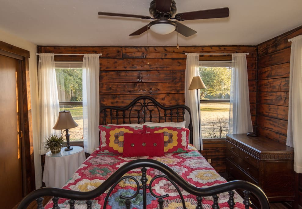 Queen bed downstairs, separated from the main living area by a curtain.