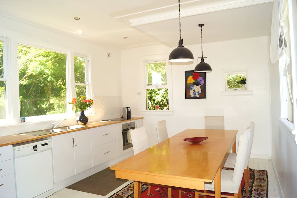 spacious and airy white kitchen with massive table and 6 dining chairs