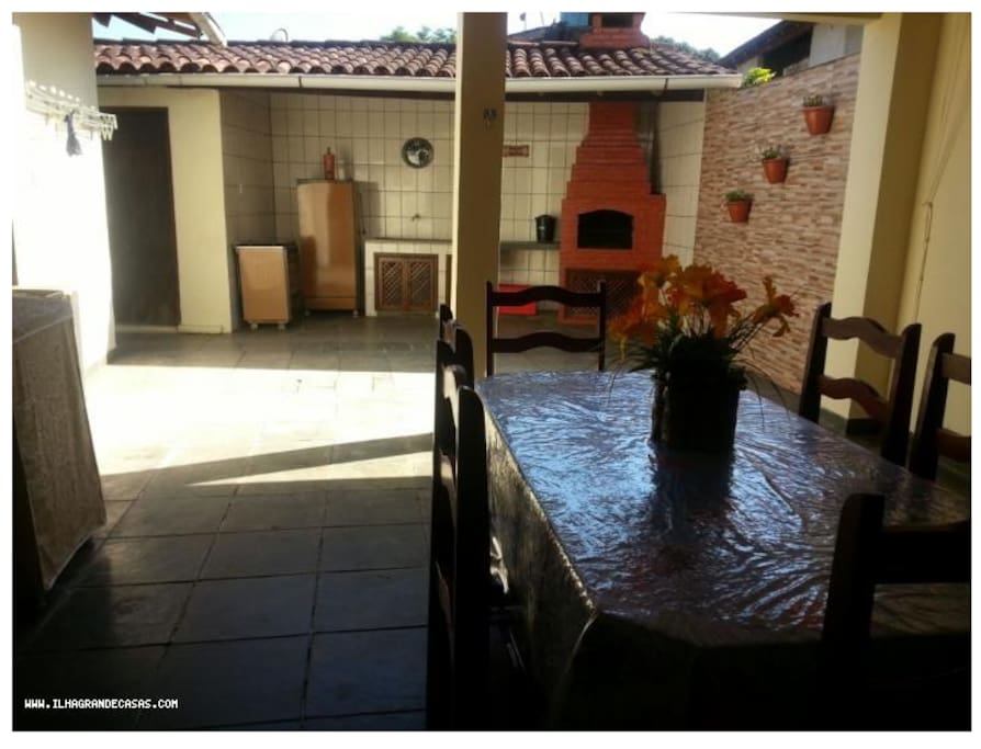 Quiosque com churrasqueira e grande quintal em volta da casa