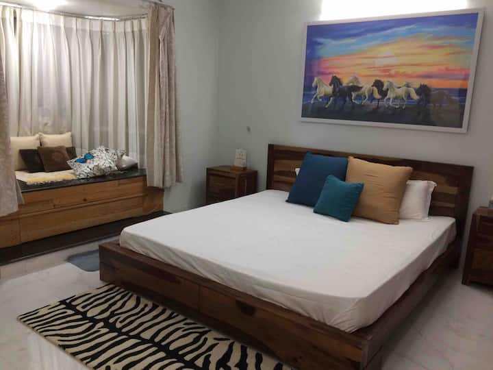 Master bedroom with king-sized bed and  a sofa in addition which can be turned into Queen sized bed ,a bay window overlooking lush green park, a very convenient  work space