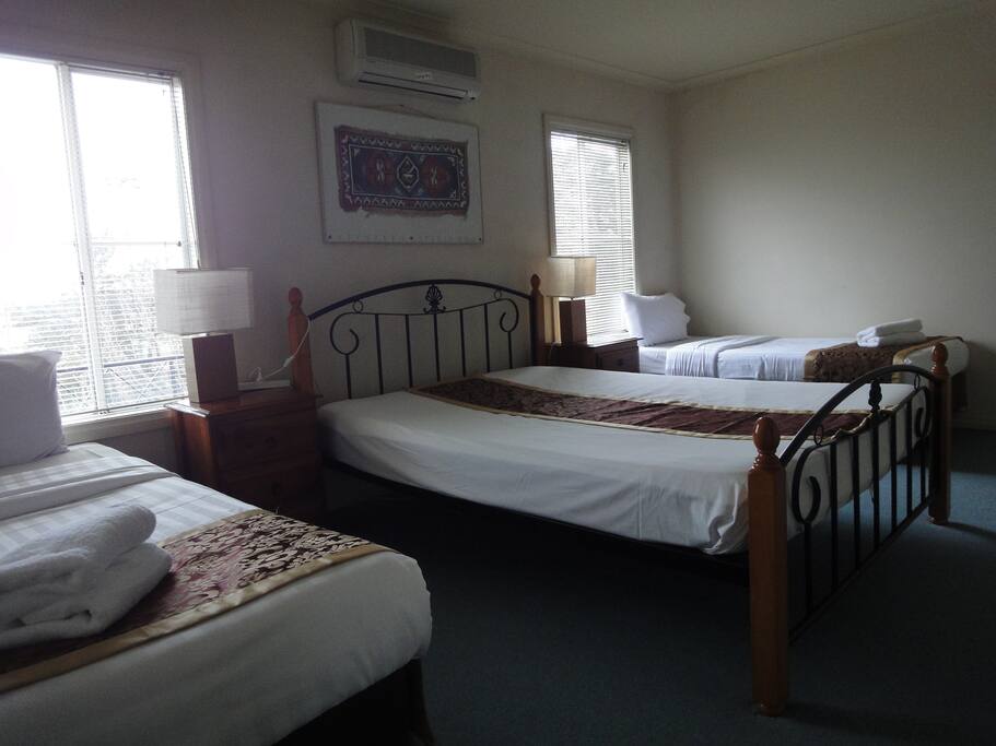 The second room upstairs with a queen bed and 2 singles