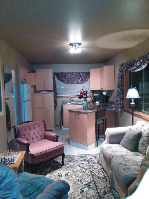 Sitting room and partial view of L shaped kitchen that overlooks back garden and gazebo.