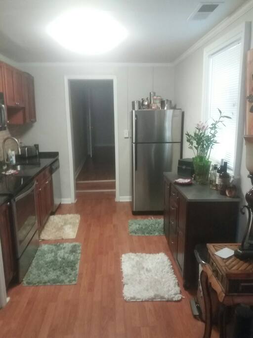 modern kitchen with stainless appliances including microwave oven and marble countertop