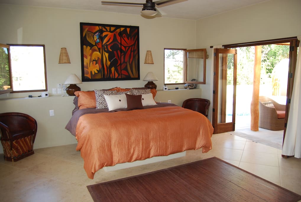 Tastefully appointed master bedroom with king bed, cozy linens, private bath and French doors with pool deck access.