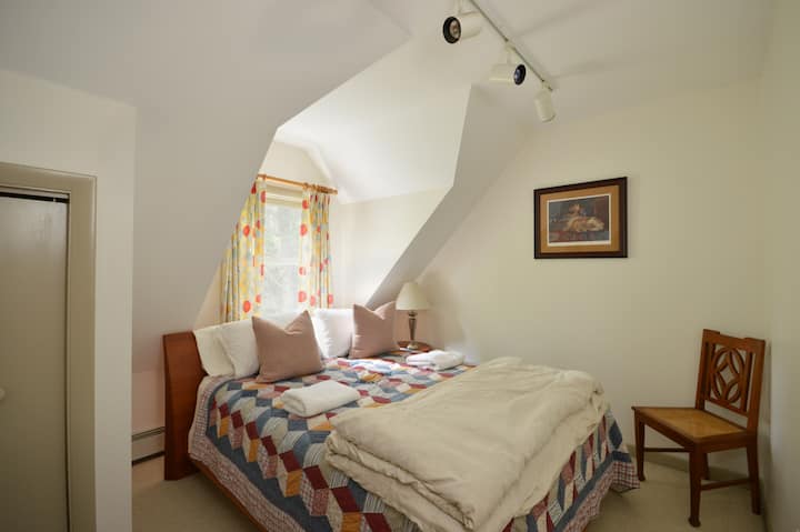 בחדר השינה השני בגודל קווין סייז יש תקרה זוויתית.