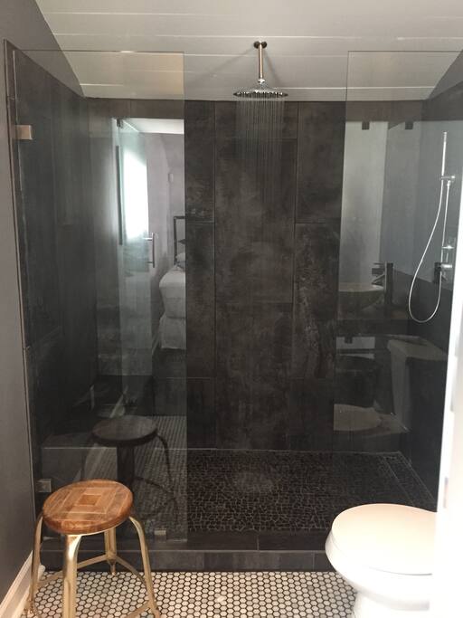 Large walk-in shower with bench, and rain feature.